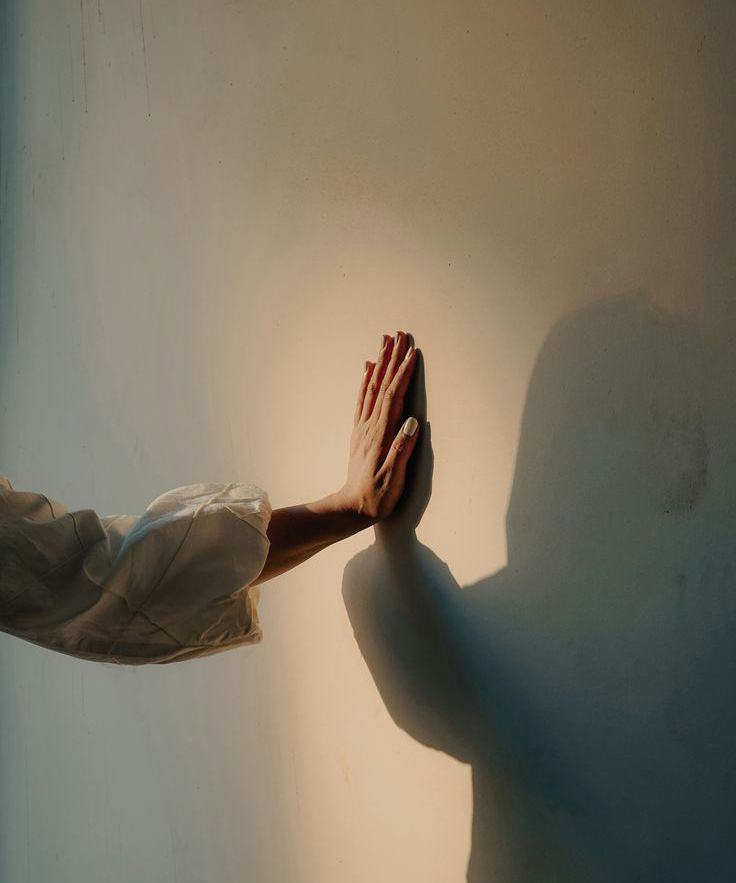 Una mano apoyada en una pared iluminada